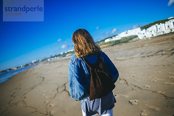 Spanien  Conil de la Frontera  Rückansicht einer jungen Frau beim Strandspaziergang