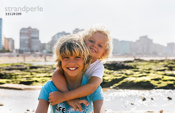 Portrait von zwei glücklichen Brüdern am Strand