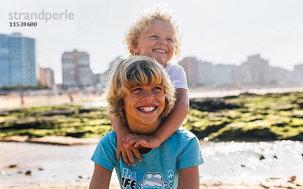 Portrait von zwei glücklichen Brüdern am Strand