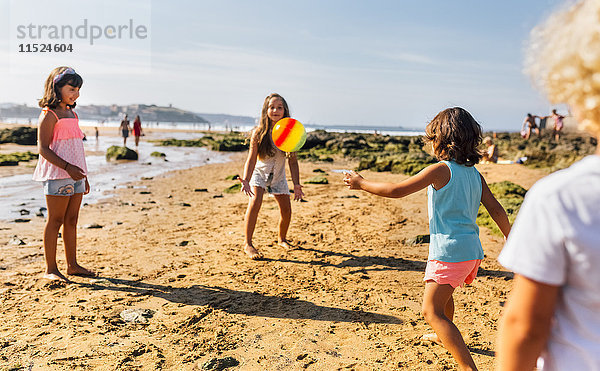 Gruppe von Kindern spielt am Strand mit Ball