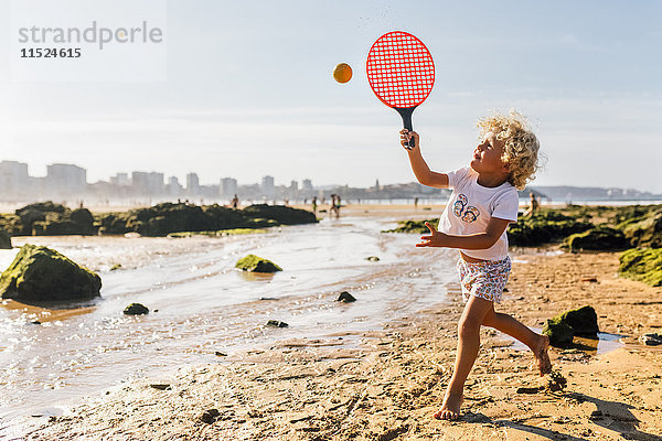 Kleiner Junge spielt Strandpaddel am Strand