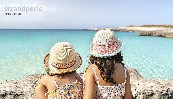 Mädchen am Strand mit Blick aufs Meer