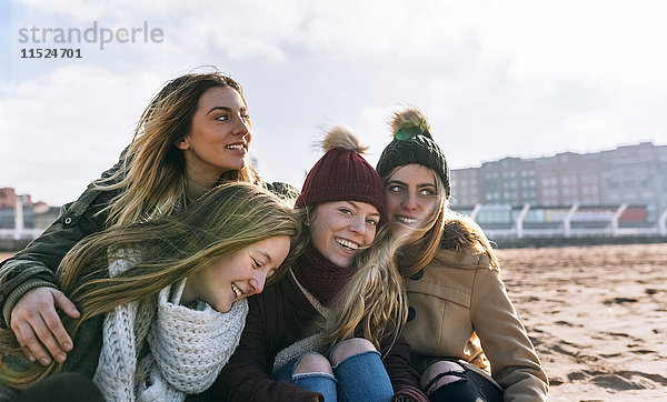 Vier glückliche Freunde  die Zeit zusammen am Strand verbringen.