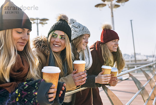 Vier Freunde mit Kaffee zum Mitnehmen im Winter