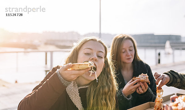 Freunde essen Pizza im Freien