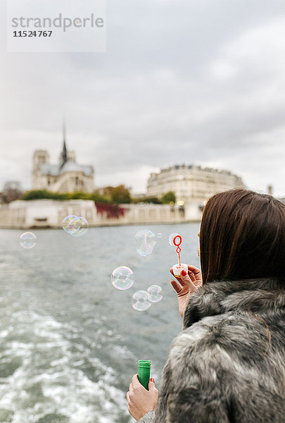 Paris  Frankreich  Touristen  die eine Kreuzfahrt auf der Seine machen und Seifenblasen blasen.