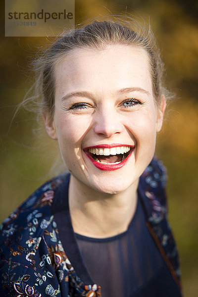 Porträt der lachenden jungen Frau im Herbst