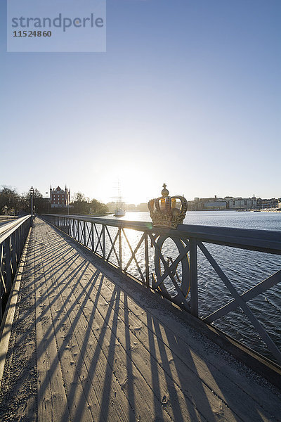 Schweden  Stockholm  Schwedische Königskrone am Geländer der Skeppsholmen Brücke bei Gegenlicht