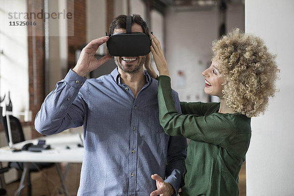 Glückliche Frau und Mann mit Virtual Reality Brille im Büro