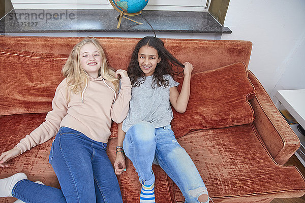 Zwei glückliche Mädchen  die sich auf der Couch entspannen