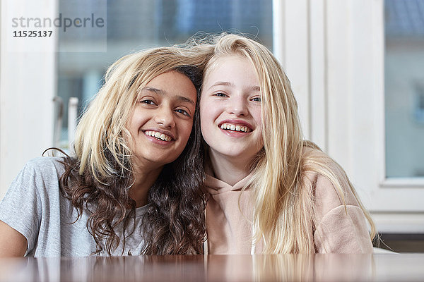 Porträt von zwei glücklichen Mädchen  die mit ihren Haaren spielen