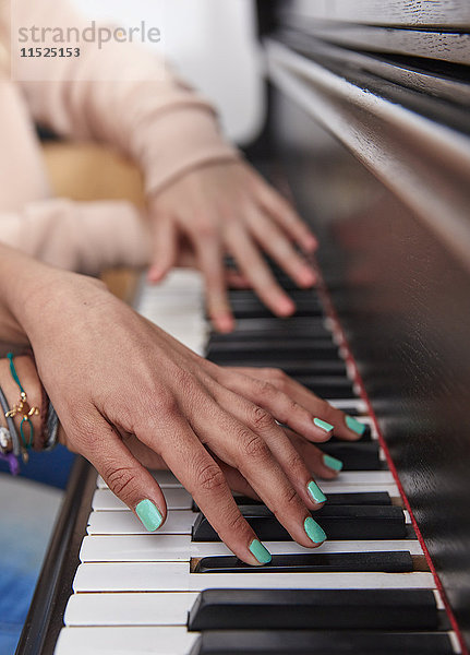 Nahaufnahme von zwei Mädchen  die zusammen Klavier spielen