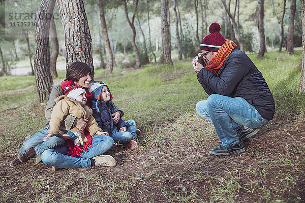 Vater fotografiert seine Familie im Wald