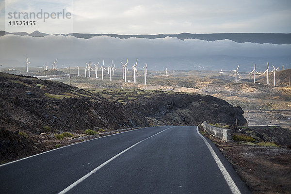 Spanien  Teneriffa  leere Landstraße mit Windrädern im Hintergrund