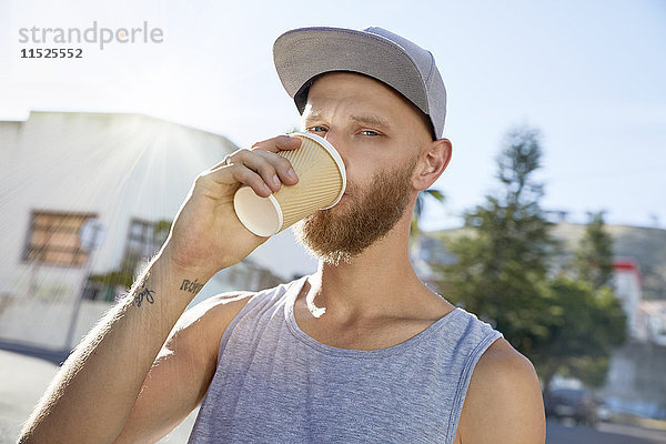 Porträt eines jungen Mannes  der Kaffee trinkt.
