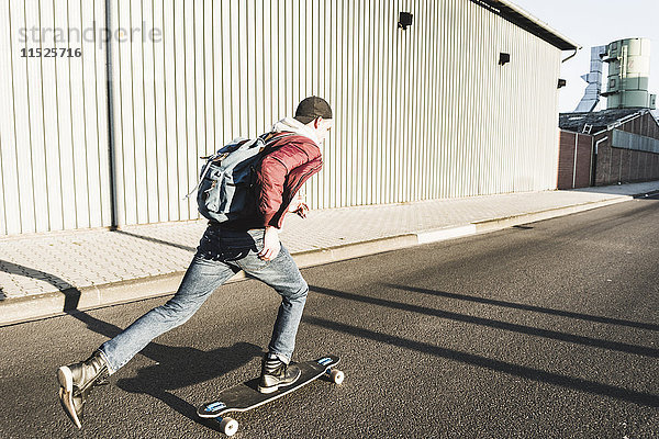Junger Mann beim Skateboardfahren auf der Straße