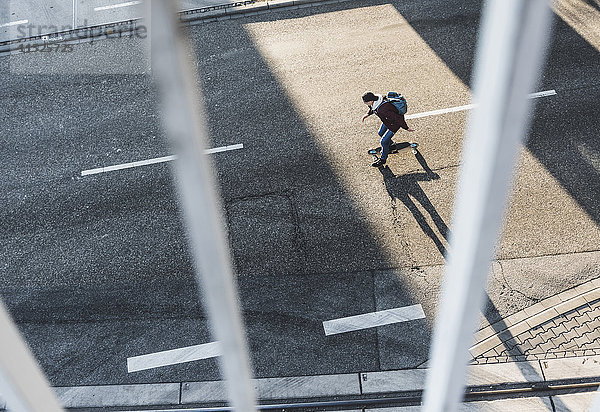 Draufsicht des jungen Mannes auf dem Skateboard auf der Straße