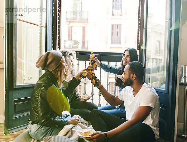 Vier Freunde klirren Bierflaschen