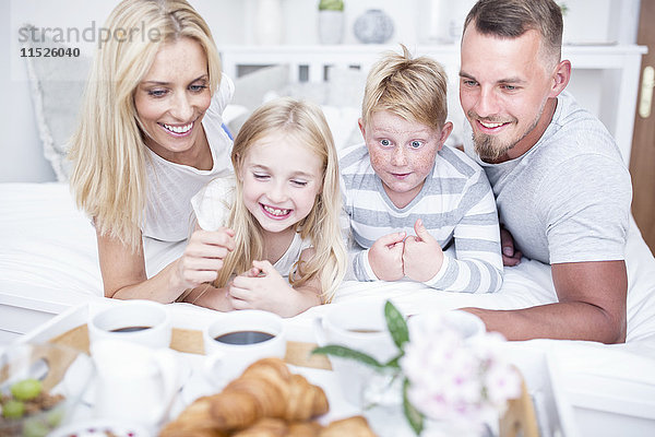 Glückliche Familie beim Frühstück im Bett