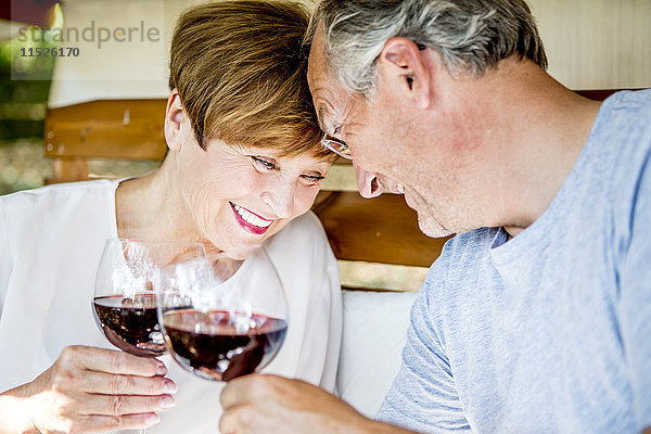 Glückliches Seniorenpaar bei einem Glas Rotwein