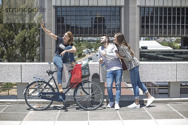 Freunde  die einen Selfie mit Einkaufstaschen und Fahrrad in der Stadt mitnehmen.