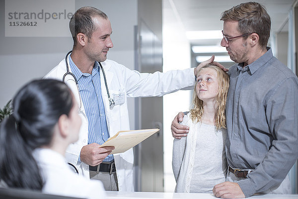 Arzt berührt Mädchen Stirn im Krankenhaus