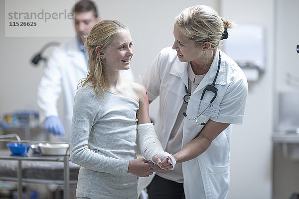 Arzt im Gespräch mit verletztem Mädchen im Krankenhaus