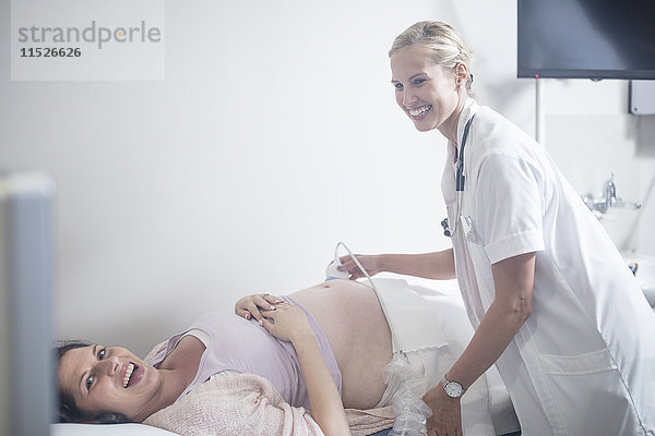 Arzt im Krankenhaus beim Sonogramm mit schwangerer Frau