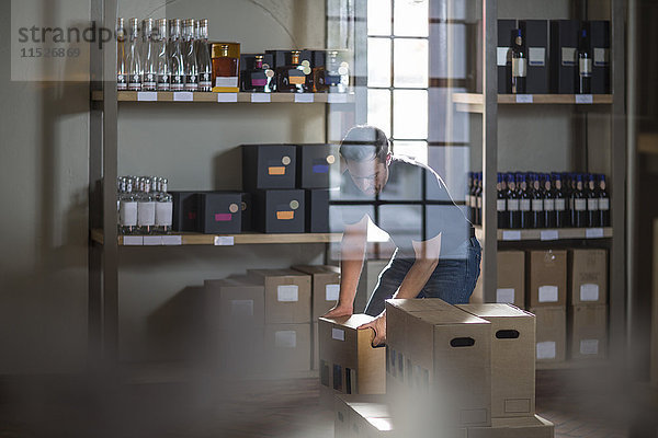 Mann beim Verpacken von Weinflaschen im Geschäft