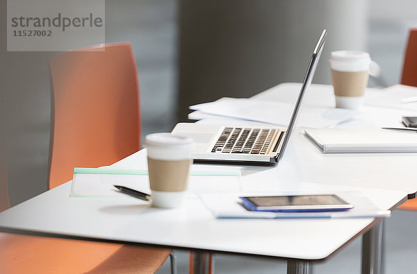 Laptop  Kaffee und Papierkram auf dem Tisch im Büro