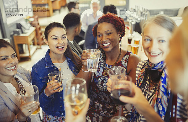 Frauenfreunde toasten Wein und Biergläser an der Bar