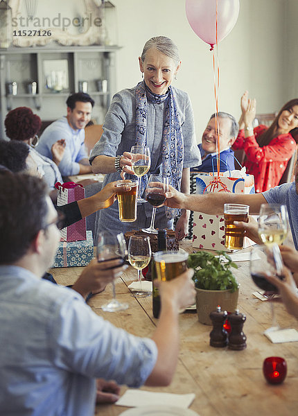 Freunde toasten Wein und Biergläser bei der Geburtstagsparty im Restaurant
