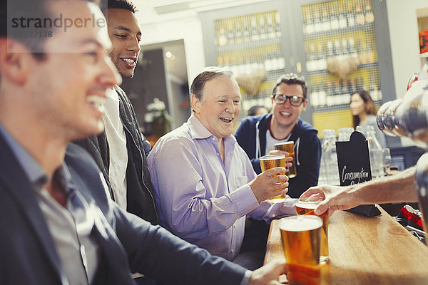 Lächelnde Männer Freunde trinken Bier an der Bar