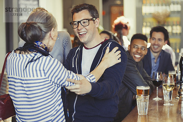 Enthusiastische Begrüßung von Mann und Frau in der Bar