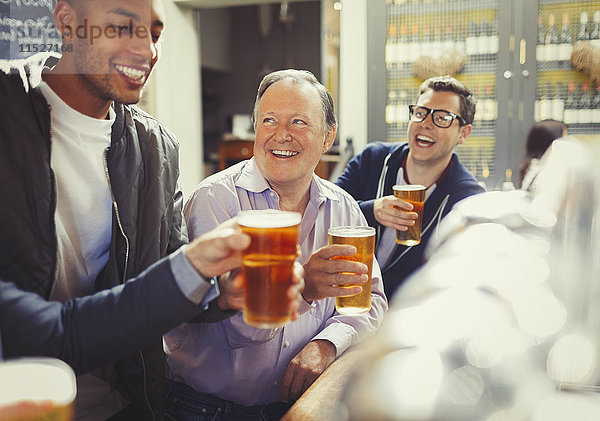 Lächelnde Männer Freunde toasten Biergläser an der Bar