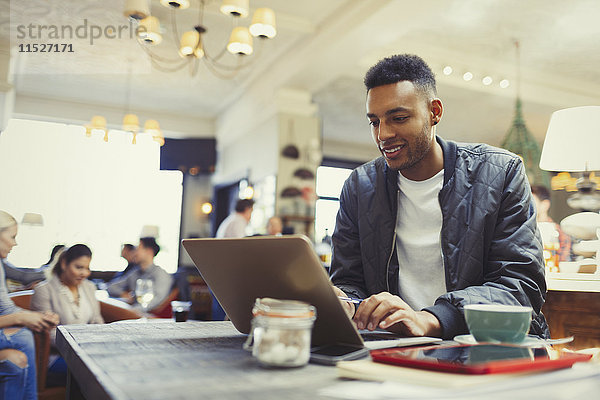 Kreativer Geschäftsmann arbeitet am Laptop im Cafe