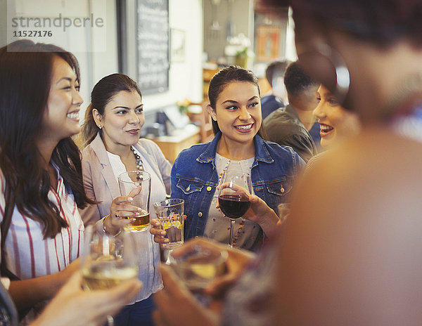 Frauenfreunde unterhalten sich und trinken Bier und Wein an der Bar.