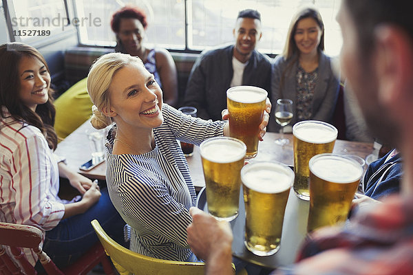 Barkeeper serviert Bier auf dem Tablett an Freunde in der Bar.