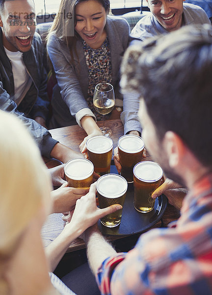 Barkeeper serviert Bier auf dem Tablett an Freunde in der Bar.