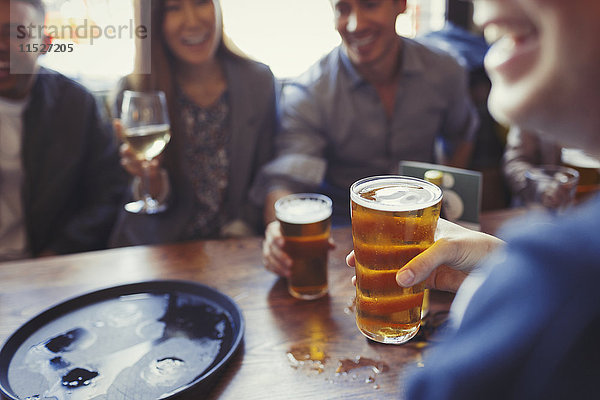 Freunde trinken Bier und Wein am Tisch in der Bar