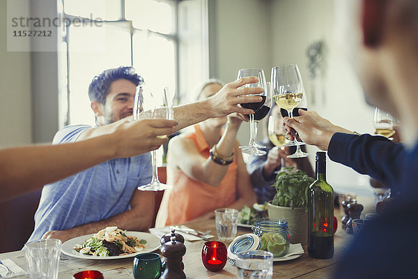 Freunde beim Feiern  Trinken von Weingläsern und Essen am Restauranttisch