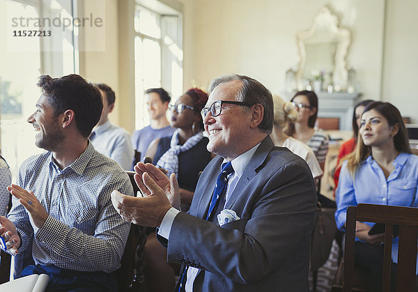 Lächelnde Geschäftsleute klatschen im Publikum der Business-Konferenz