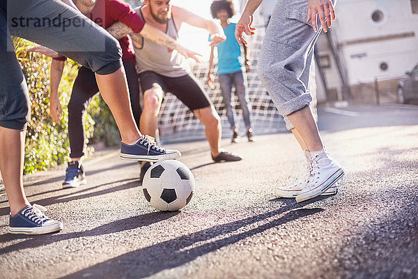 Freunde spielen Fußball in der Sommerstraße