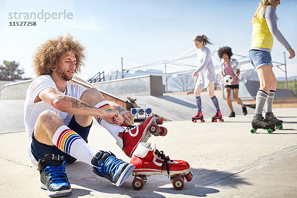 Mann auf Rollschuhen im sonnigen Skatepark