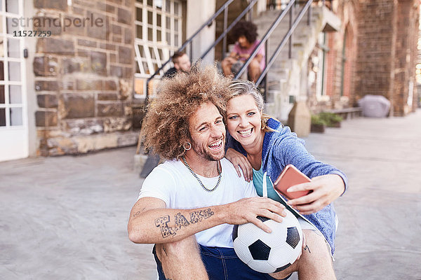 Pärchen mit Fußballspieler mit Fotohandy