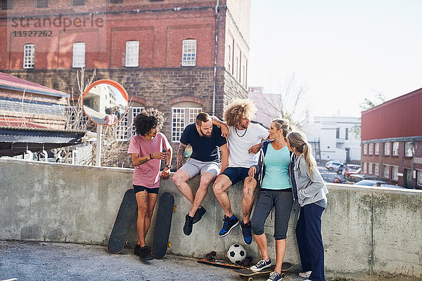 Freunde mit Skateboards an der urbanen Sommerwand