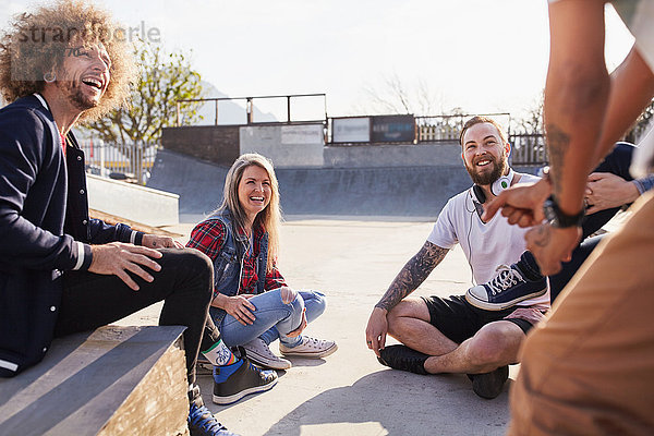 Freunde beim Reden und Abhängen im sonnigen Skatepark