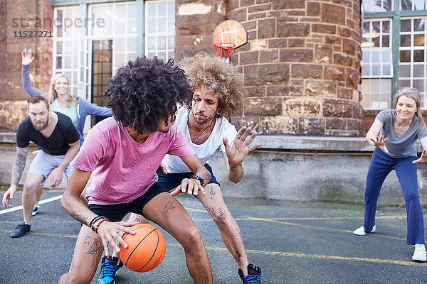 Freunde beim Basketball auf dem städtischen Basketballplatz