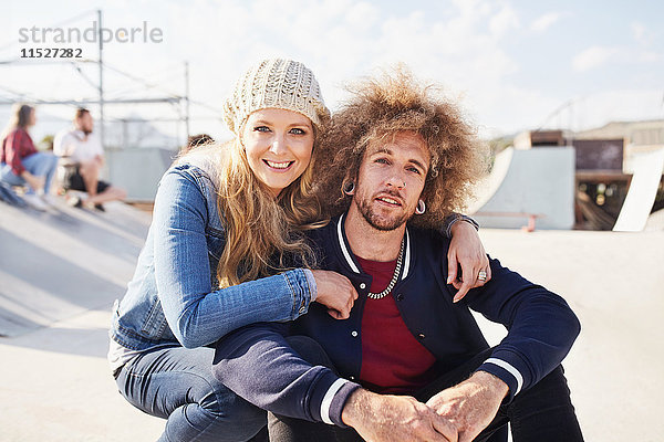 Portrait lächelndes Paar im sonnigen Skatepark