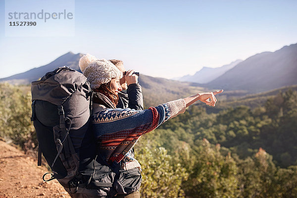 Junges Paar beim Wandern  Blick auf die Sonne mit dem Fernglas